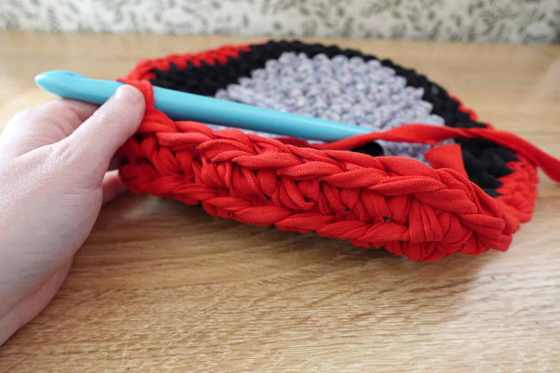 crochet pattern with blue black and red fabric close up step 2