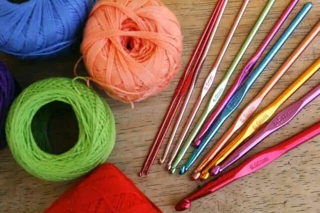 Crochet hooks and yarn laid out on a work table