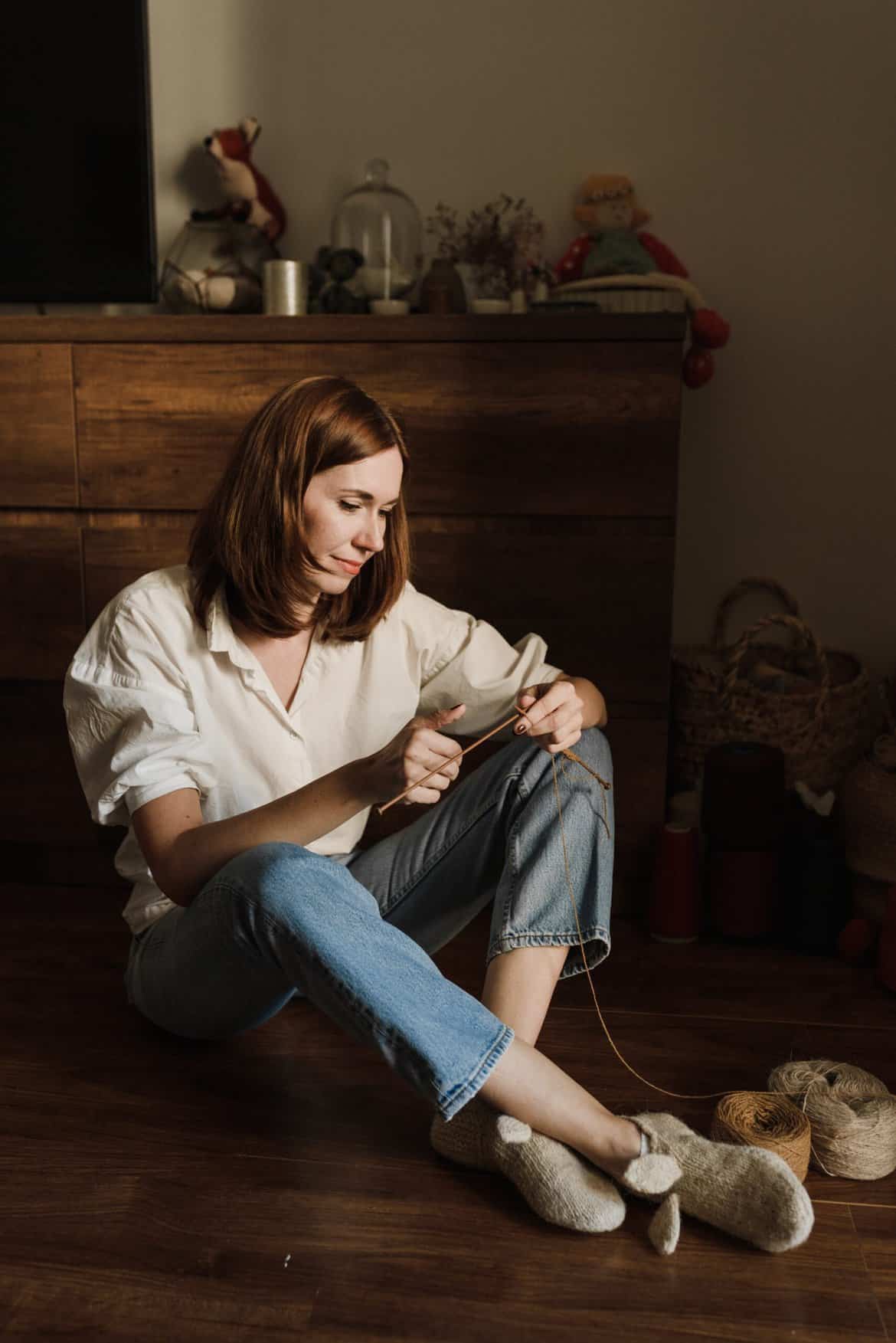 Young Woman Sitting on the Floor Knitting