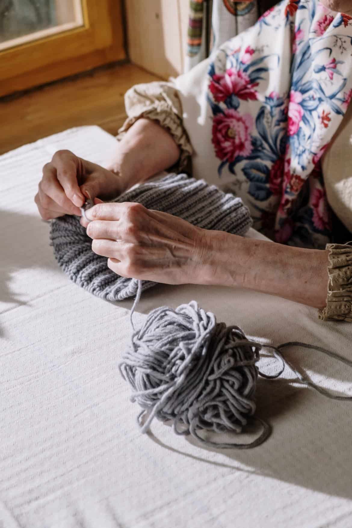 Elderly Woman Knitting with Gray Yarn