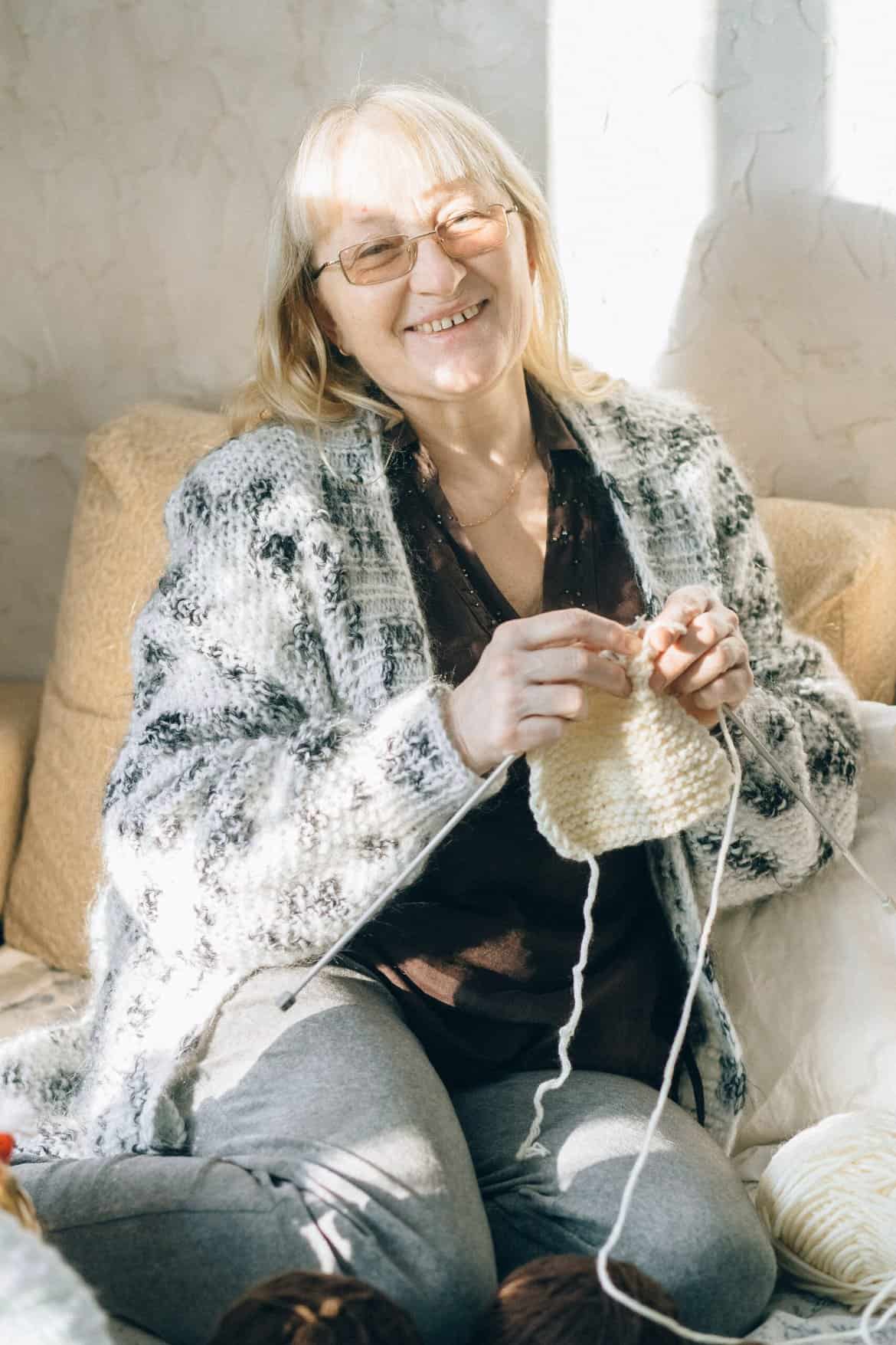 Elderly Woman Sitting on a Couch Knitting