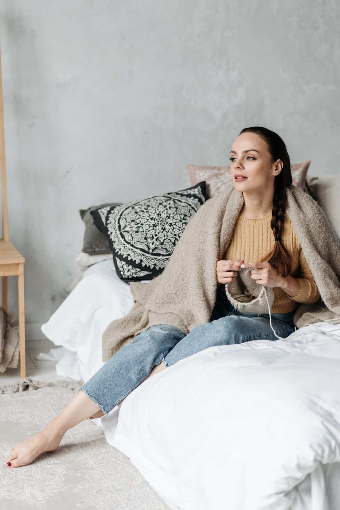 Woman Knitting While Relaxing on a Bed