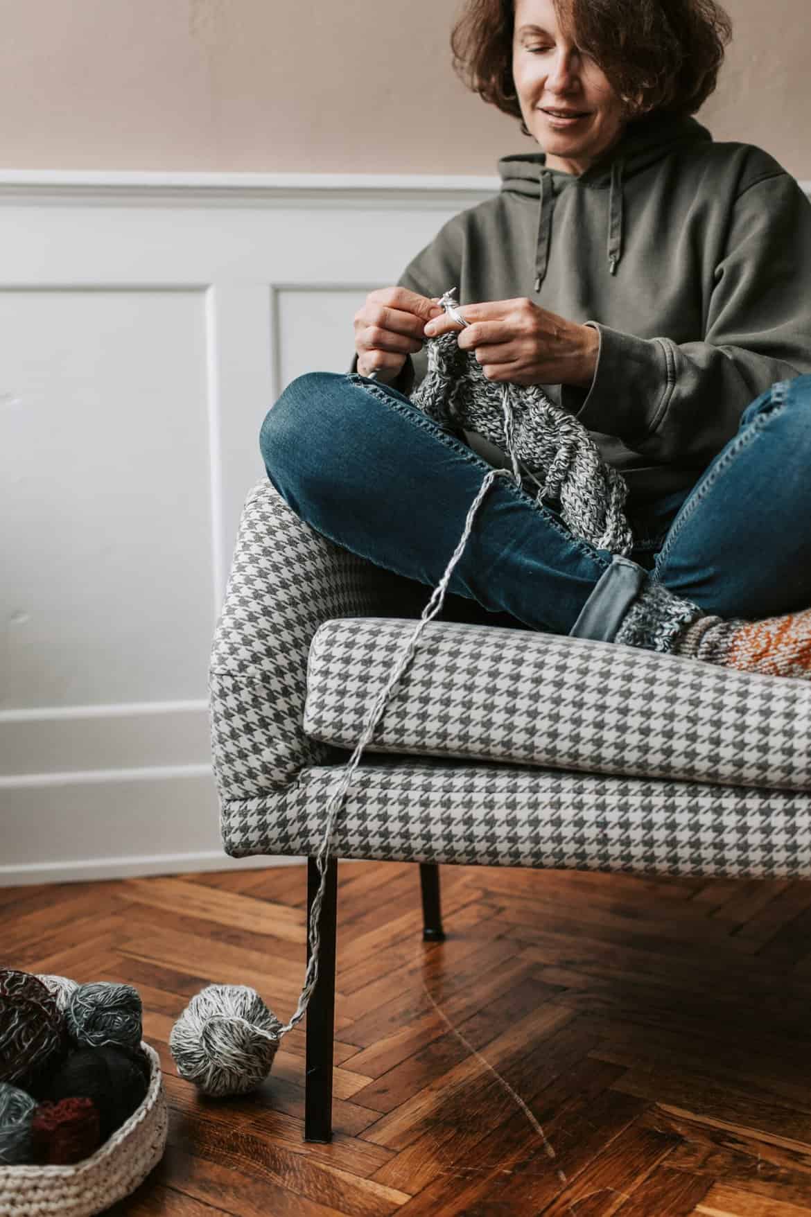 A Woman Sitting in a Chair Knitting