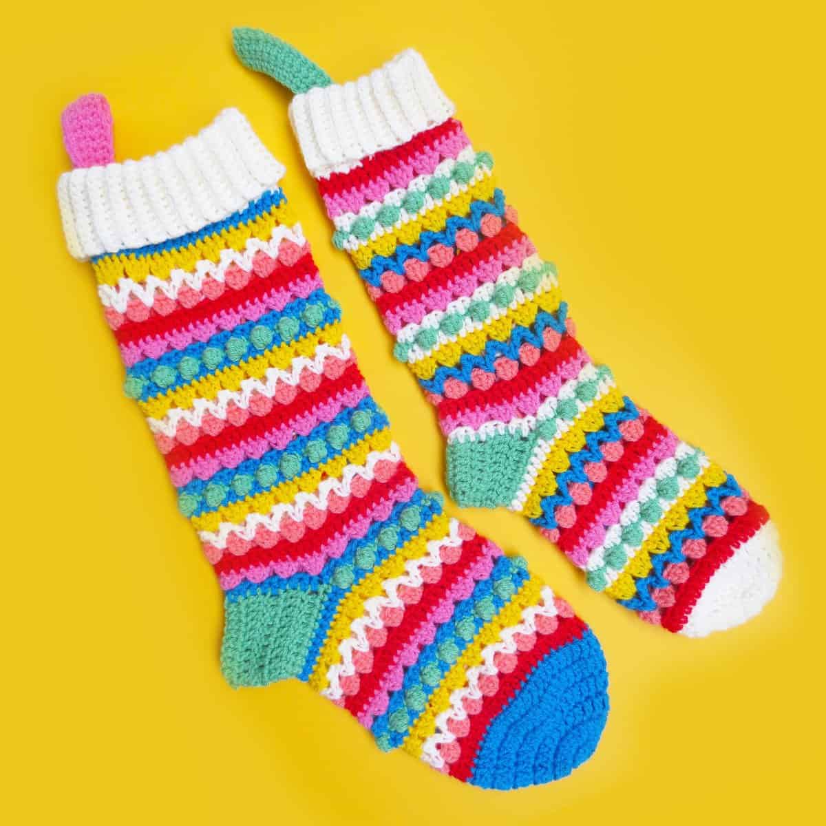 Crocheted multi-colored socks on a yellow background